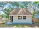 Home exterior featuring a light-colored design, gable roof, chimney, and updated landscaping at 8521 N 29Th St, Tampa, FL 33604