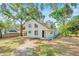 Inviting home exterior features mature trees, a light color scheme, and a covered side porch at 8521 N 29Th St, Tampa, FL 33604