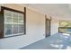 Inviting covered porch with view to side yard through window and glass paneled door at 8521 N 29Th St, Tampa, FL 33604