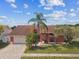 Aerial view of home featuring a well-manicured lawn, mature landscaping, and brick driveway at 8601 Chadwick Dr, Tampa, FL 33635