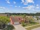 Aerial view of home with colorful exterior, mature landscaping, neighborhood, and blue skies at 8601 Chadwick Dr, Tampa, FL 33635