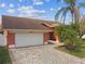 The home's exterior features a two-car garage, beautiful brick driveway, and well-manicured landscaping at 8601 Chadwick Dr, Tampa, FL 33635