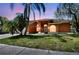 The front exterior features beautiful architecture, arched windows, and mature palm trees at 8601 Chadwick Dr, Tampa, FL 33635
