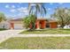 Charming single-story home with a well-manicured lawn, brick driveway and lush palm trees at 8601 Chadwick Dr, Tampa, FL 33635