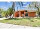 Charming single-story home with a well-manicured lawn, brick driveway and lush palm trees at 8601 Chadwick Dr, Tampa, FL 33635