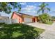 Single-story home with a well-maintained lawn, brick driveway and lush palm trees at 8601 Chadwick Dr, Tampa, FL 33635