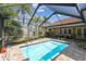 Lush backyard featuring a sparkling pool with screened enclosure, perfect for enjoying sunny days outdoors at 8601 Chadwick Dr, Tampa, FL 33635