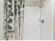 Shower with white tiling and brushed nickel hardware and leaf-patterned shower curtain at 8601 Chadwick Dr, Tampa, FL 33635