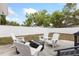 Relaxing backyard with white Adirondack chairs surrounding a fire pit and a white privacy fence for seclusion at 914 E North St, Tampa, FL 33604