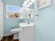 Clean and modern bathroom featuring white fixtures, window, and wood floors at 914 E North St, Tampa, FL 33604