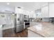 Updated kitchen with granite counters, stainless appliances, and white cabinets at 914 E North St, Tampa, FL 33604