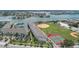 Scenic aerial view of a waterfront property featuring a marina, tennis courts, and baseball field at 9201 Captiva Cir, St Pete Beach, FL 33706