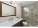Bathroom featuring a single sink vanity, a large mirror, and a glass enclosed walk-in shower at 9201 Captiva Cir, St Pete Beach, FL 33706