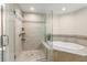 Bathroom featuring a glass enclosed walk-in shower and a soaking tub with mosaic tile accents at 9201 Captiva Cir, St Pete Beach, FL 33706