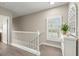 Bright hallway with stylish floors, white railings, and a decorative console table with plant at 9201 Captiva Cir, St Pete Beach, FL 33706
