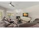 Living room features tile fireplace, modern ceiling fan, and sliding glass doors to porch at 9201 Captiva Cir, St Pete Beach, FL 33706