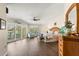 Bright main bedroom featuring wood flooring, a ceiling fan, a dresser, and slider doors leading to a balcony at 9201 Captiva Cir, St Pete Beach, FL 33706