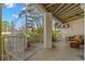 Inviting covered patio with spiral staircase, tile flooring, and comfortable wicker furniture, perfect for relaxing outdoors at 9201 Captiva Cir, St Pete Beach, FL 33706