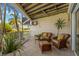 Relaxing outdoor patio space with wicker furniture and views of lush greenery, perfect for enjoying the coastal breeze at 9201 Captiva Cir, St Pete Beach, FL 33706