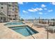 Refreshing community pool and jacuzzi area with lounge chairs, overlooking the waterfront and lush landscaping at 9201 Captiva Cir, St Pete Beach, FL 33706