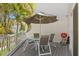 Open porch with table, chairs, grill, and views of the complex and trees at 9201 Captiva Cir, St Pete Beach, FL 33706