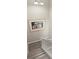 View of staircase with light gray wood flooring and white painted wood bannister and a framed print hanging on the wall at 9201 Captiva Cir, St Pete Beach, FL 33706