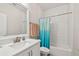 Bathroom with white subway tile, modern vanity, and a bathtub with colorful shower curtain at 925 Monticello N Blvd, St Petersburg, FL 33703