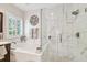 Bright bathroom featuring a large tub, glass enclosed shower with pebble floor, and luxurious finishes at 925 Monticello N Blvd, St Petersburg, FL 33703