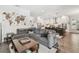 Open-concept living room with a large gray sofa and a view into the modern, white kitchen at 925 Monticello N Blvd, St Petersburg, FL 33703