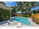 Inviting backyard pool with a sun shelf and lush tropical landscaping for privacy at 925 Monticello N Blvd, St Petersburg, FL 33703