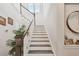 Staircase with wood treads and white risers, complemented by a wooden handrail and a decorative mirror at 925 Monticello N Blvd, St Petersburg, FL 33703