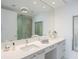 Well-lit bathroom features double sinks with vanity, a glass enclosed shower, and large mirror at 100 1St N Ave # 2703, St Petersburg, FL 33701