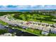 A high-angle aerial view shows a home with a screened-in pool, located on a canal with backyard boat dock at 1028 Signet Dr, Apollo Beach, FL 33572