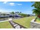 A pristine backyard with lush green lawn and a private dock with a boat and jet ski at 1028 Signet Dr, Apollo Beach, FL 33572