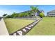 Large grassy backyard leads to a screened-in pool area, bordered by lush trees and landscaping at 1028 Signet Dr, Apollo Beach, FL 33572