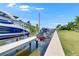 Backyard with a private boat dock and lift for a boat and jet ski on a sunny day at 1028 Signet Dr, Apollo Beach, FL 33572