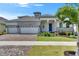 Stunning single-Gathering home featuring a three-car garage, lush landscaping, and a charming covered entry at 1028 Signet Dr, Apollo Beach, FL 33572