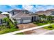 Beautiful two-story home featuring a brick driveway, three-car garage, and a stone facade and nicely landscaped lawn at 1028 Signet Dr, Apollo Beach, FL 33572