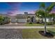 Charming single-Gathering home with an attached three-car garage and manicured landscaping at dusk at 1028 Signet Dr, Apollo Beach, FL 33572