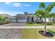 Charming home with a brick driveway, a three car garage, and lush green landscaping at 1028 Signet Dr, Apollo Beach, FL 33572