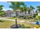 Beautiful home exterior showcasing well-maintained landscaping, swaying palm trees and a brick-paved driveway at 1028 Signet Dr, Apollo Beach, FL 33572