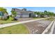 Single-Gathering home showcasing a brick driveway, three car garage, and landscaped yard at 1028 Signet Dr, Apollo Beach, FL 33572