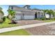 Exterior view of a home featuring a stone facade, three-car garage, and manicured landscaping at 1028 Signet Dr, Apollo Beach, FL 33572