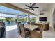 Outdoor patio with an outdoor dining set, sitting area, TV, ceiling fans and a screened-in porch by the pool at 1028 Signet Dr, Apollo Beach, FL 33572