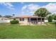 Expansive backyard featuring a well-maintained lawn, mature trees, a patio, and a white fence at 1038 Shenandoah Ln, Spring Hill, FL 34606