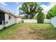 Expansive backyard featuring a well-maintained lawn, mature trees, and a white fence for privacy and relaxation at 1038 Shenandoah Ln, Spring Hill, FL 34606