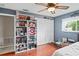 Bedroom with a ceiling fan, a closet, and shelves filled with memorabilia, offering ample storage at 1038 Shenandoah Ln, Spring Hill, FL 34606