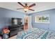 Cozy bedroom showcasing a window, a dresser with television, and relaxing blue walls at 1038 Shenandoah Ln, Spring Hill, FL 34606