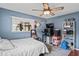 Well-lit bedroom featuring a computer, windows, ceiling fan, and blue walls at 1038 Shenandoah Ln, Spring Hill, FL 34606