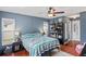 A cozy bedroom with a ceiling fan and a bookshelf, bathed in soft, natural light from the window at 1038 Shenandoah Ln, Spring Hill, FL 34606